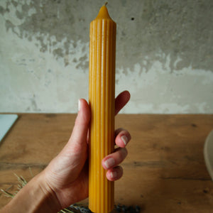 Long Pillar Beeswax Candle by Bee Baltic hold by a hand