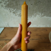 Load image into Gallery viewer, Long Pillar Beeswax Candle by Bee Baltic hold by a hand
