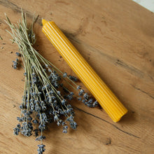 Load image into Gallery viewer, Long Pillar Beeswax Candle by Bee Baltic next to Lavenders
